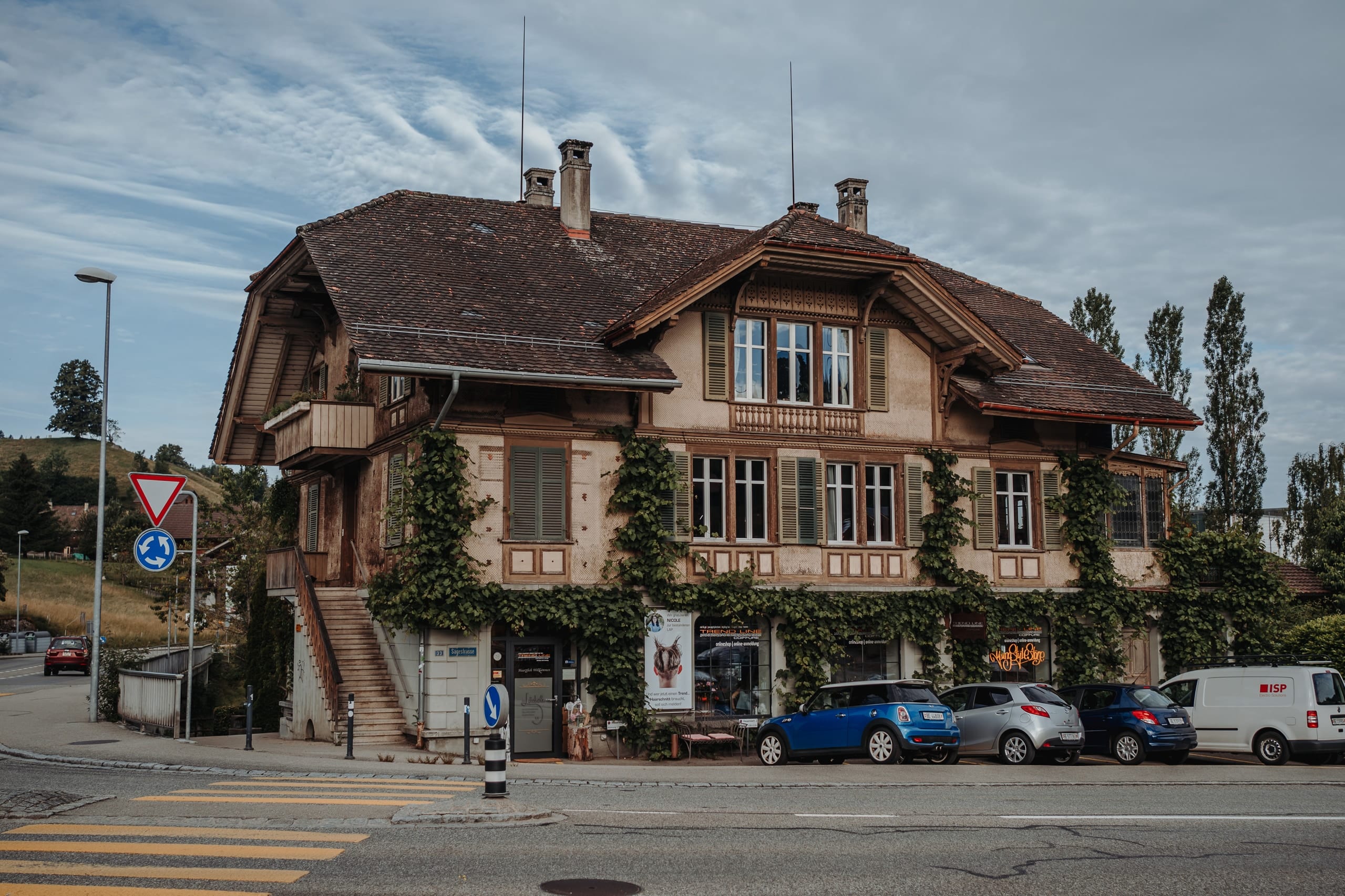 Ein altes, mit Efeu bewachsenes Haus an einer Strasse