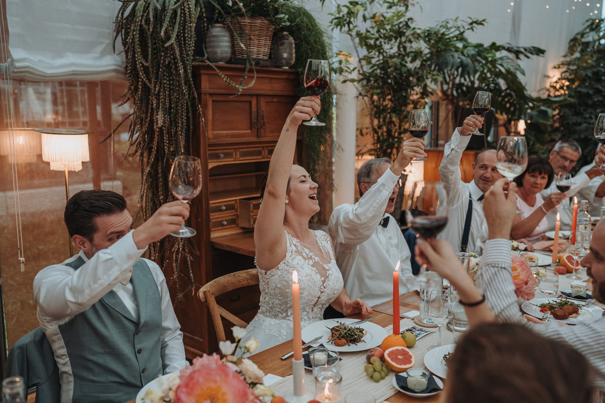 Die Braut und Gäste stossen an der Tafel an