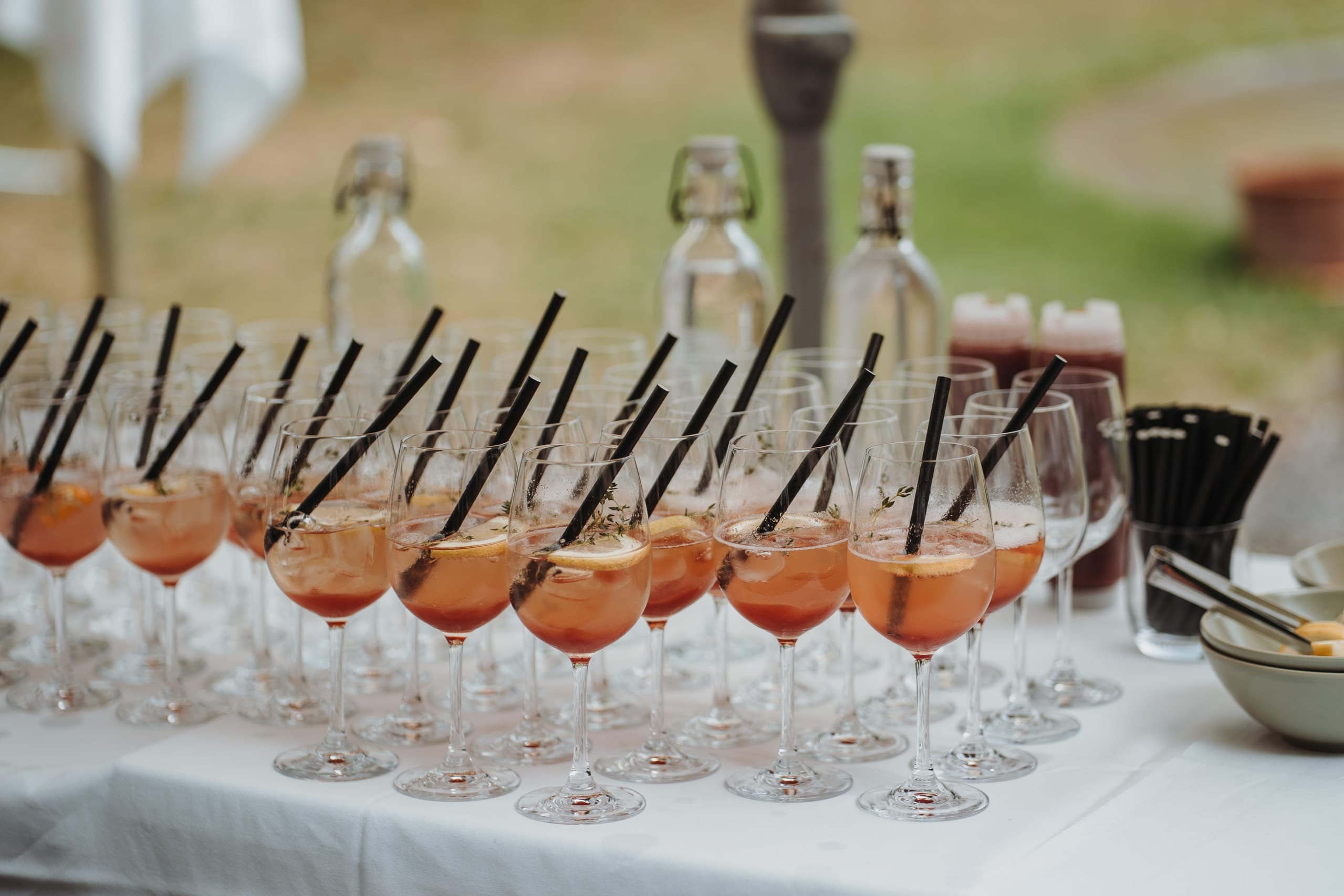 Aperitif-Gläser mit Strohhalmen auf einem weissen Tisch