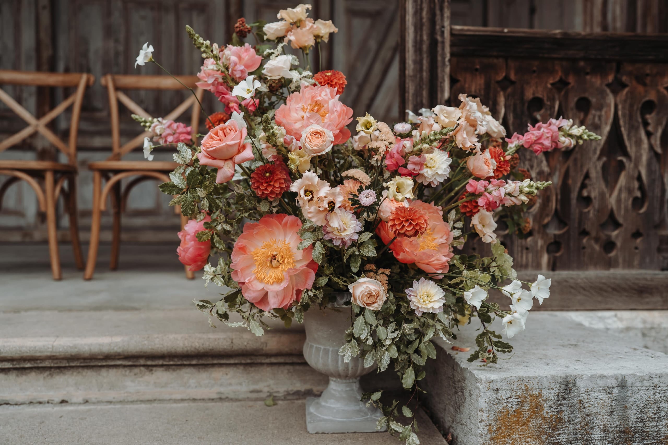 Ein grosses Blumenarrangement mit Pfingstrosen auf der Treppe des Holzspeichers