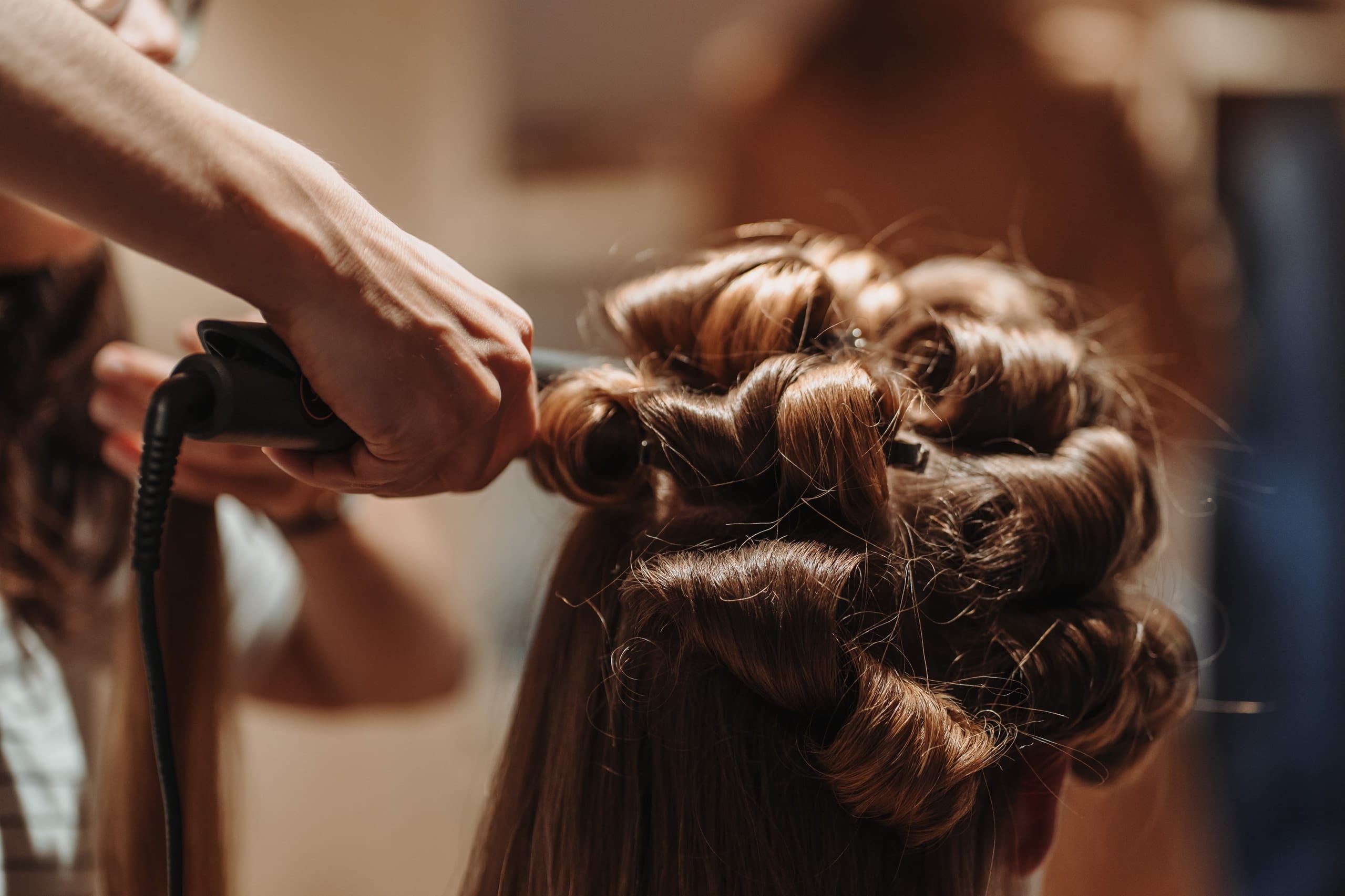 Die Haare der Braut werden in Locken gelegt
