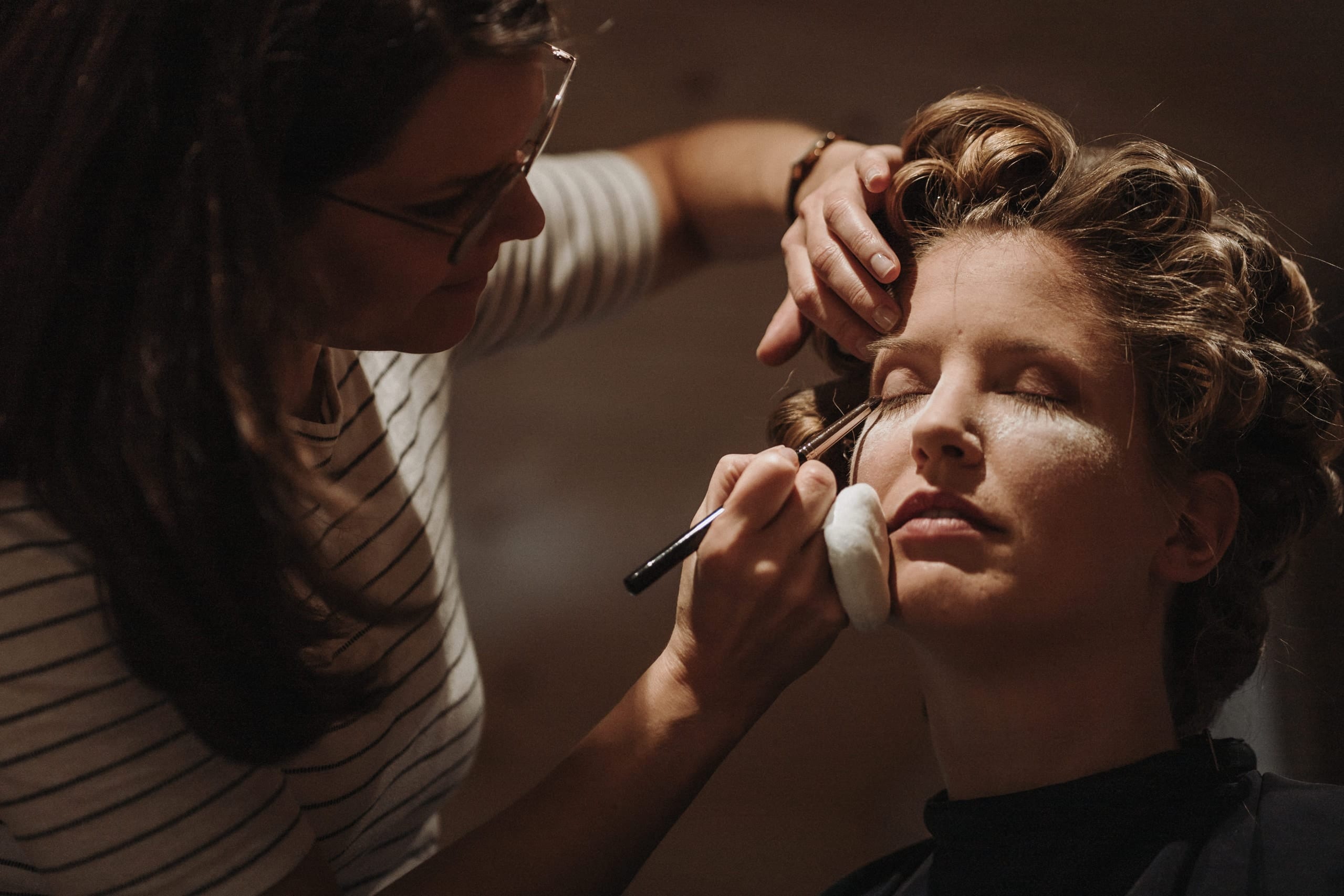 Die Braut mit geschlossenen Augen beim Schminken