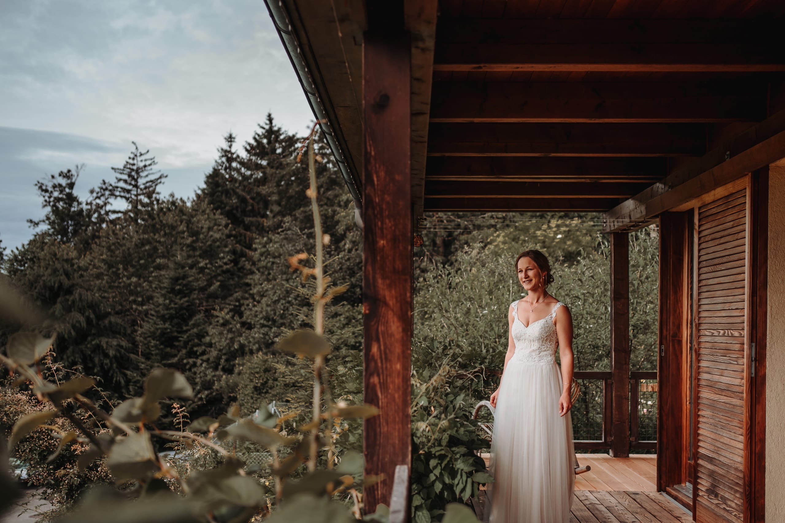 Die Braut im Brautkleid auf einer überdachten Veranda
