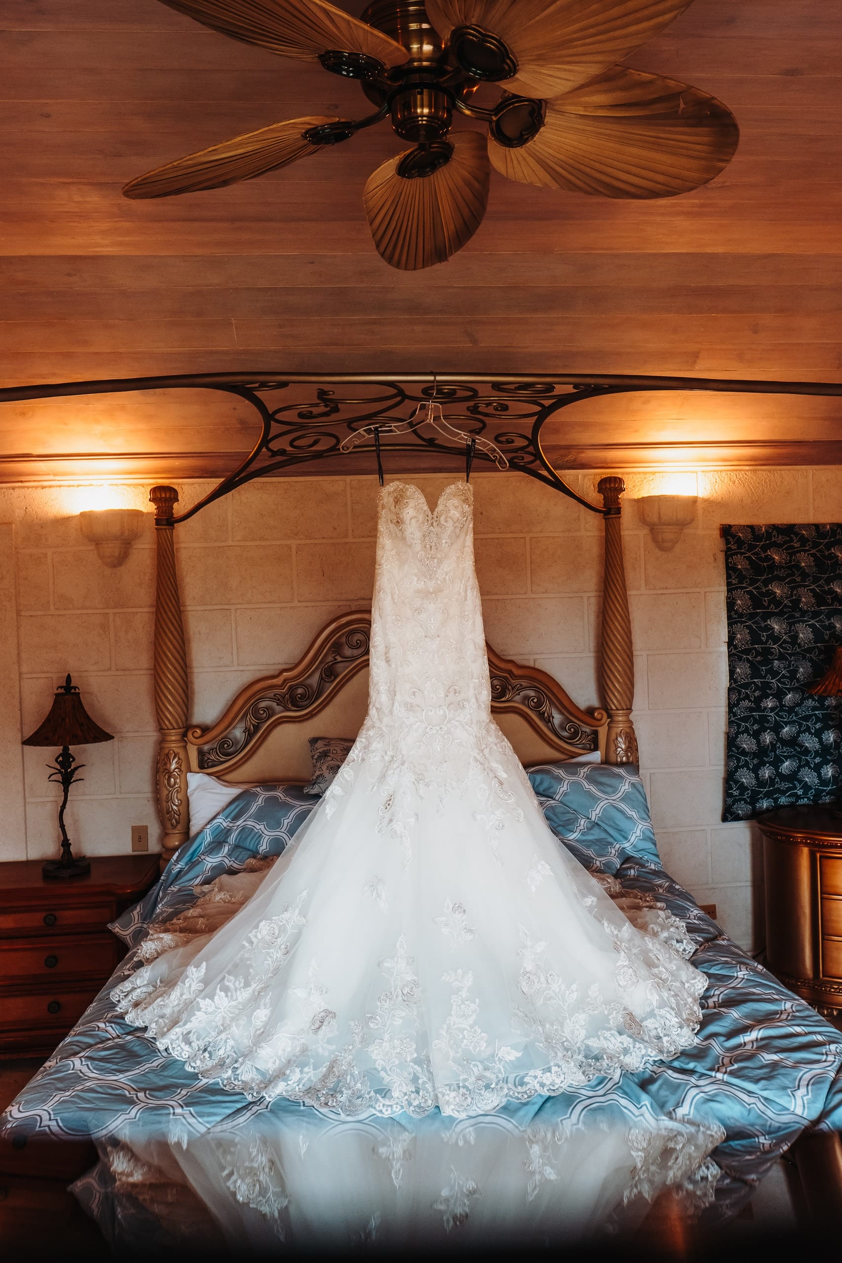 Brautkleid aus Spitze auf einem Himmelbett in der Villa Carpathia, darüber ein Deckenventilator