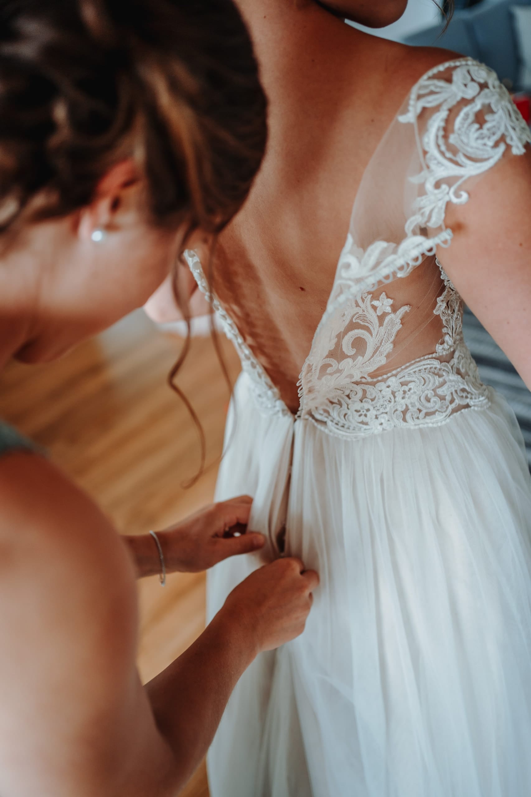 Das Brautkleid mit Spitzenrücken wird zugeknöpft