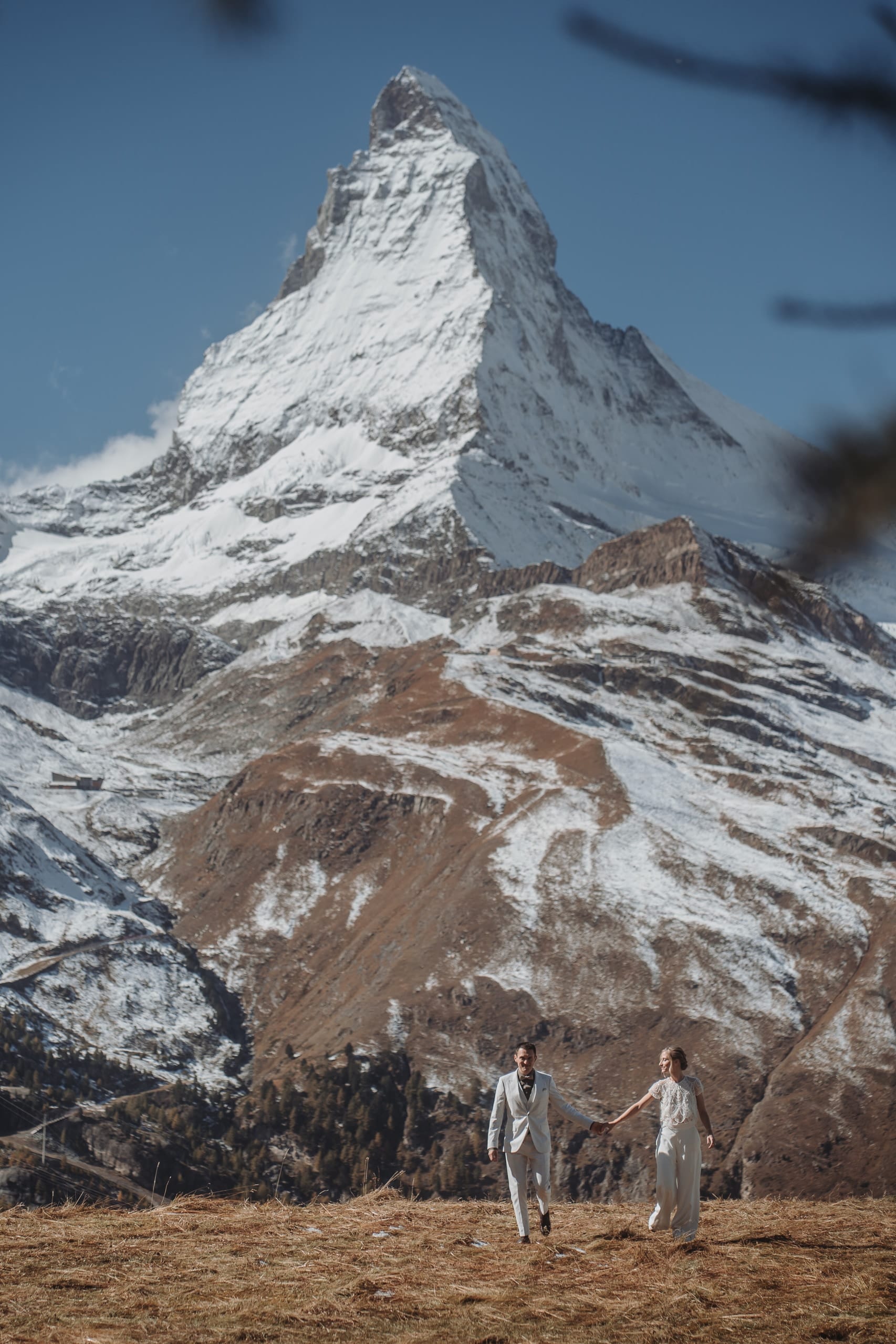 Das Brautpaar Hand in Hand, ganz klein unter dem mächtigen Matterhorn