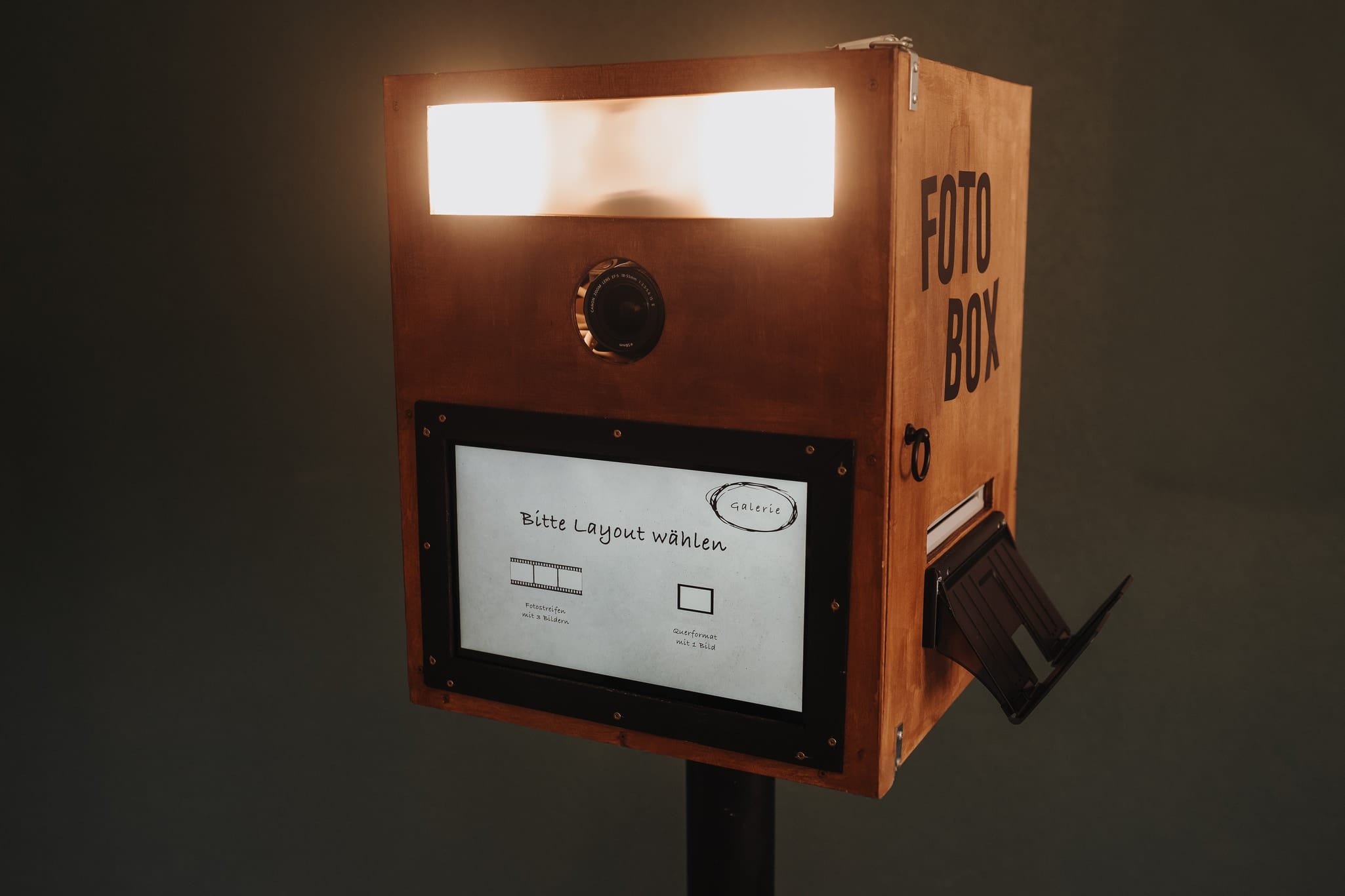 Die Fotobox aus Holz mit beleuchtetem Blitz, Kamera und Bildschirm