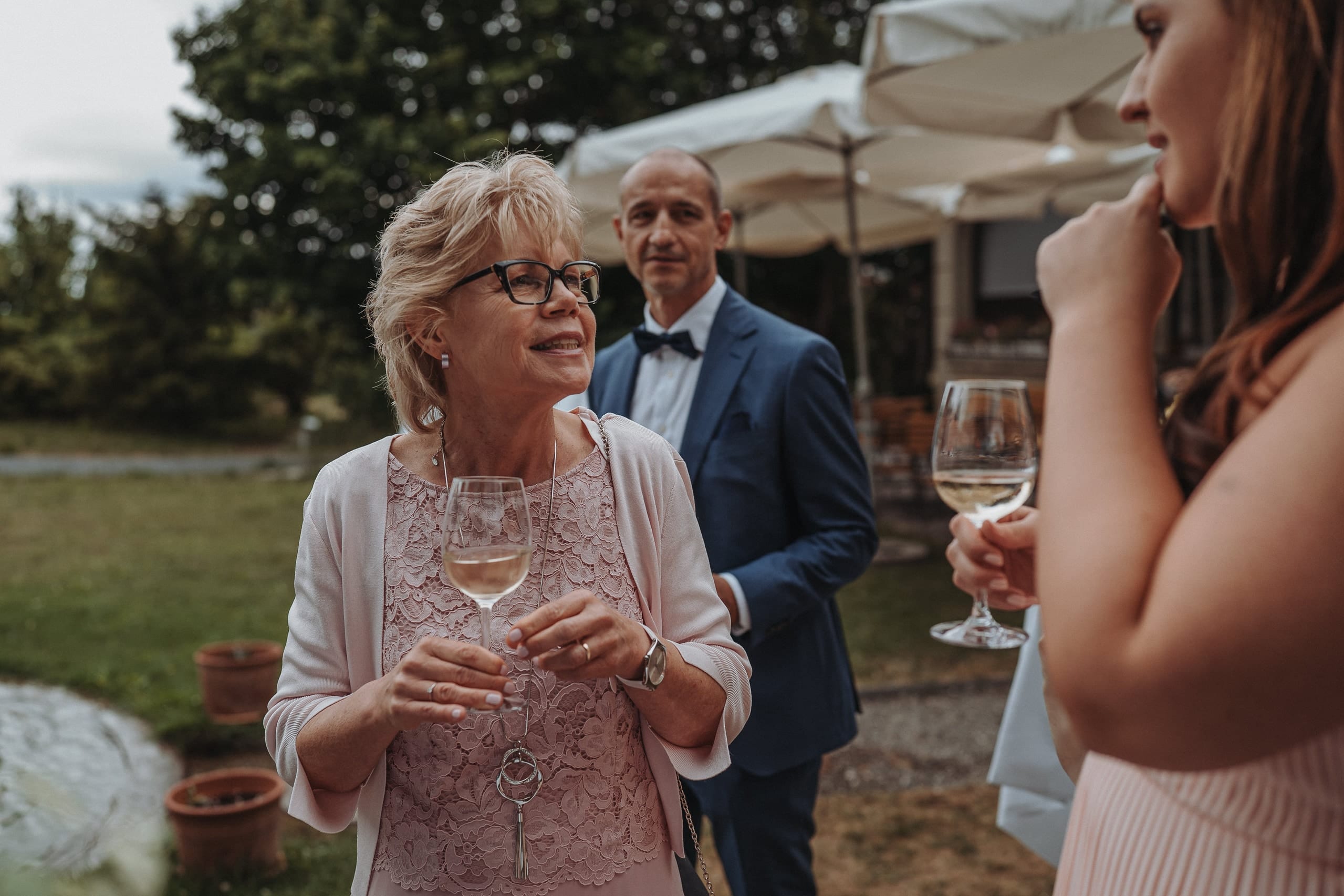 Eine Frau mit Weissweinglas im Garten