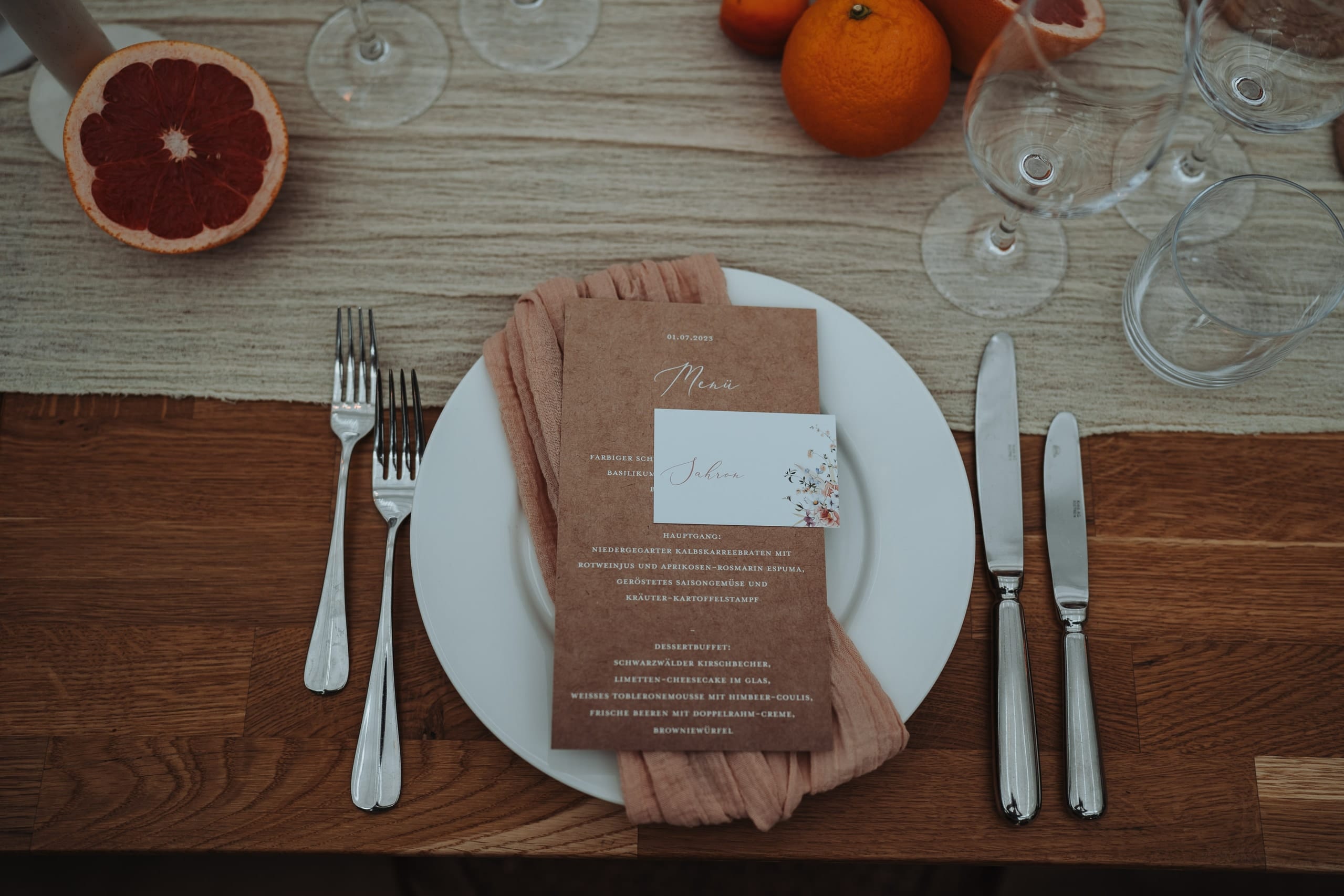 Ein Gedeck mit Menükarte, Grapefruit und Orangen