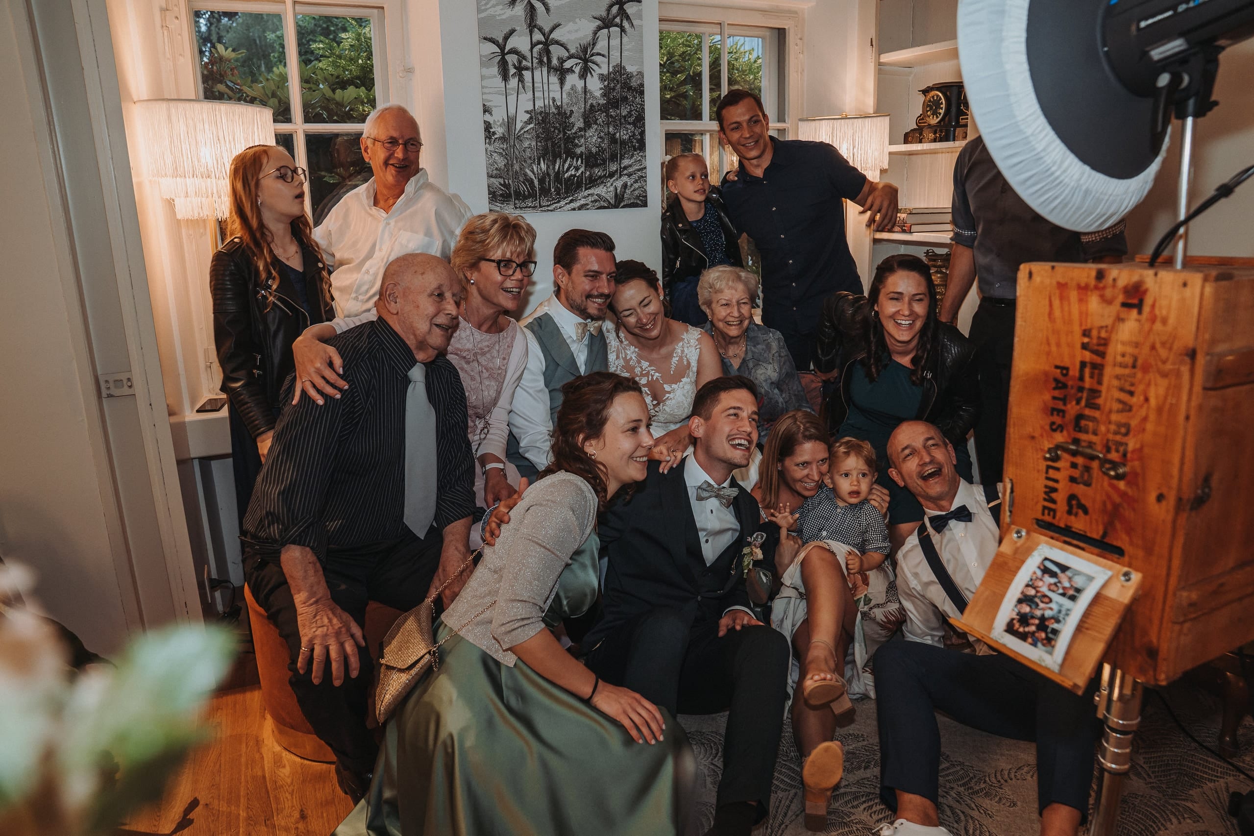 Das Brautpaar und viele Gäste beim Gruppenfoto auf dem Sofa