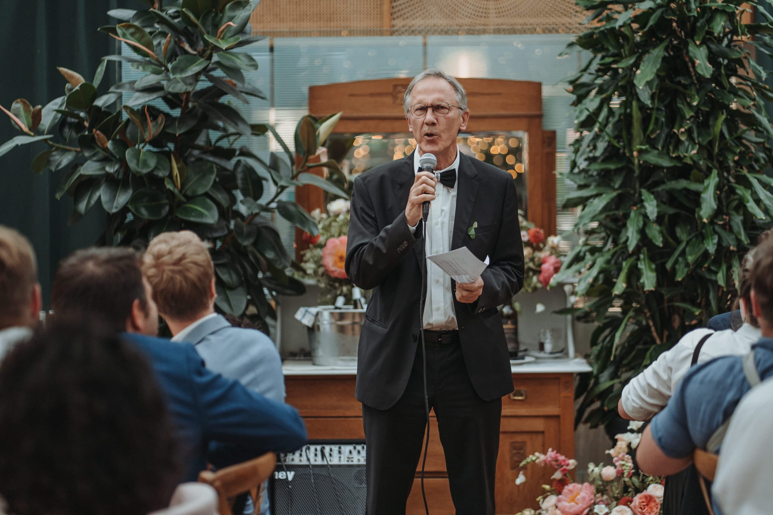 Ein Mann hält im Hochzeitssaal eine Rede