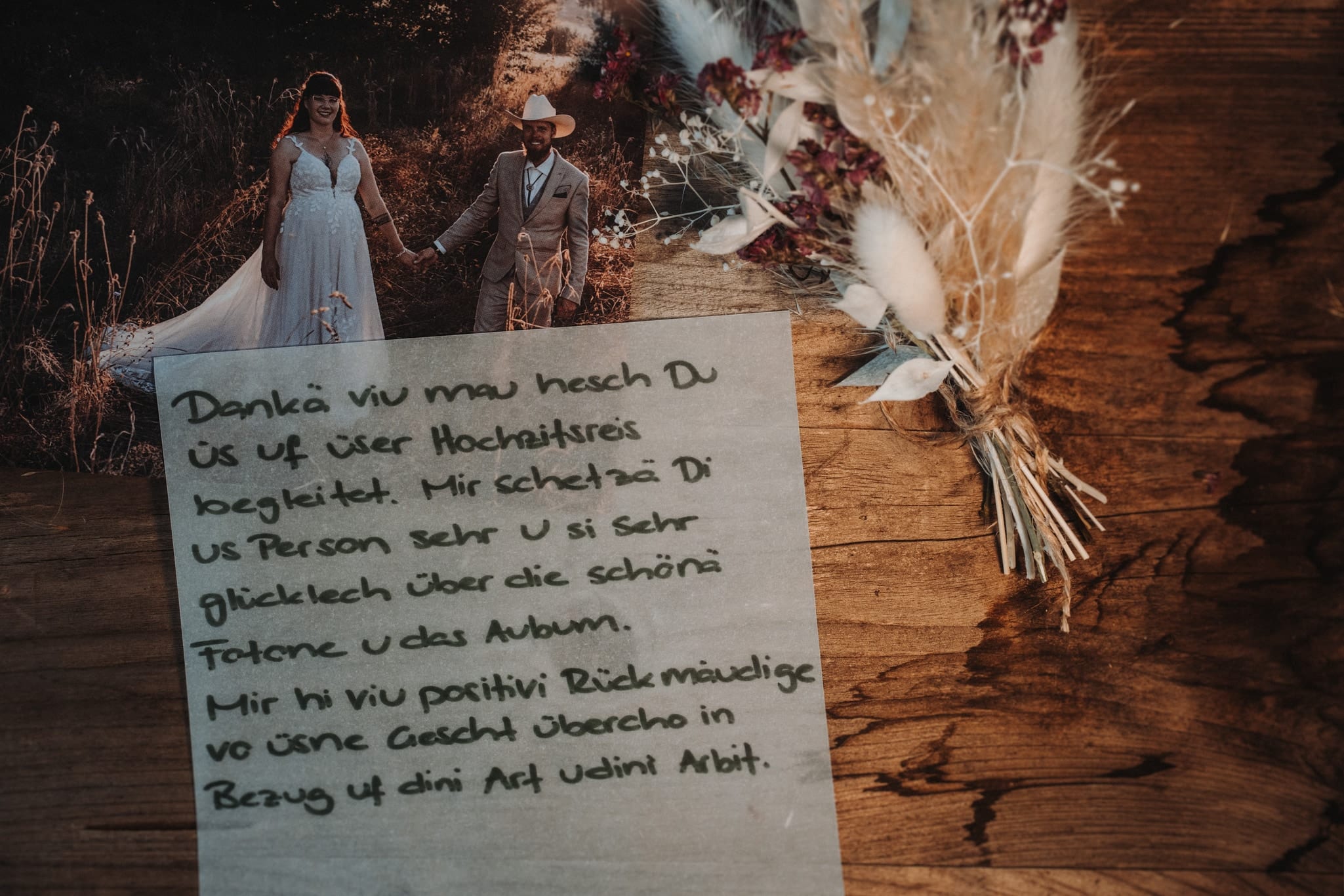 Handgeschriebene Karte in Berndeutsch auf transparentem Papier über einem Hochzeitsfoto