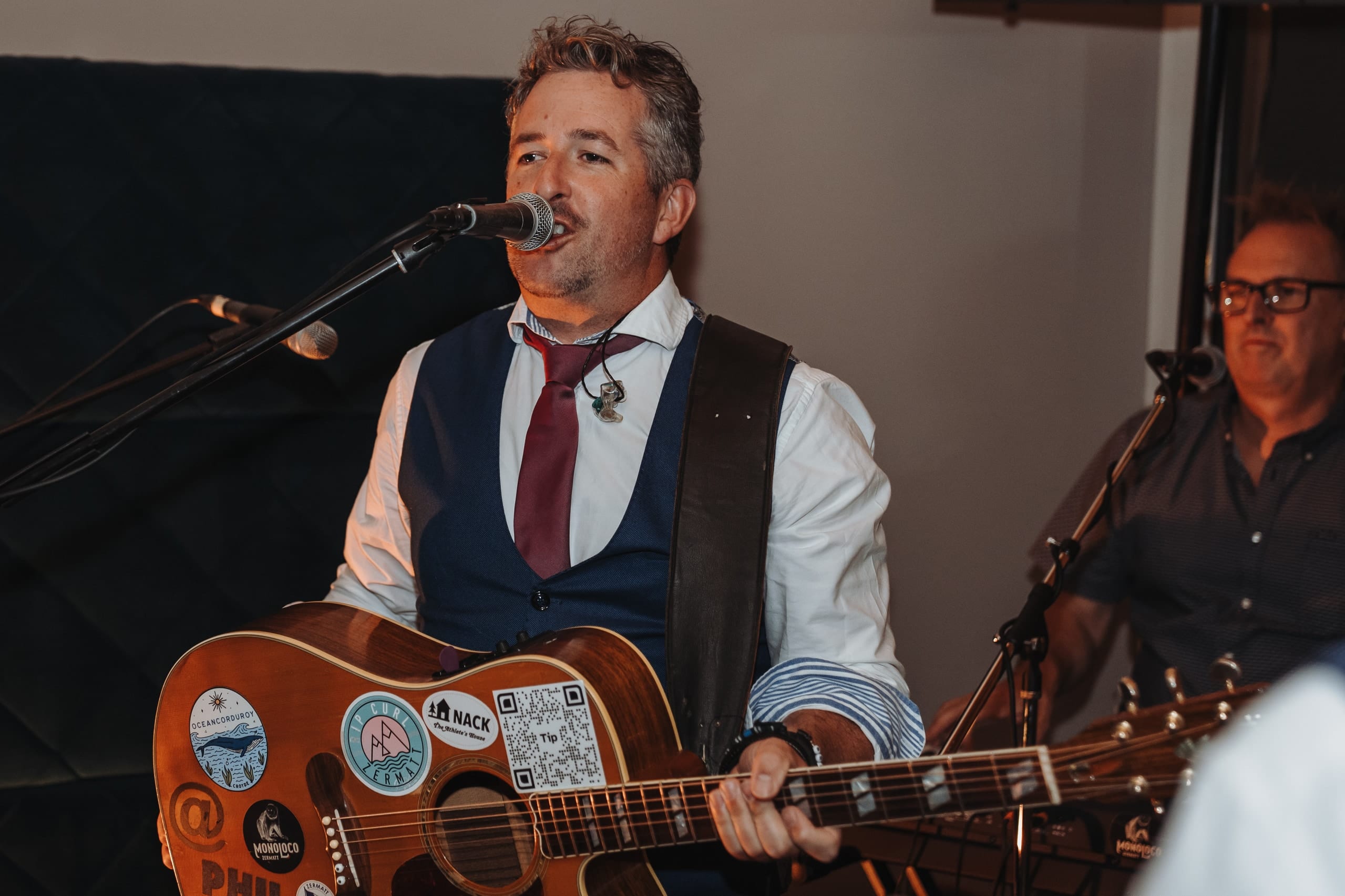 Ein Sänger mit Gitarre spielt an der Hochzeitsparty