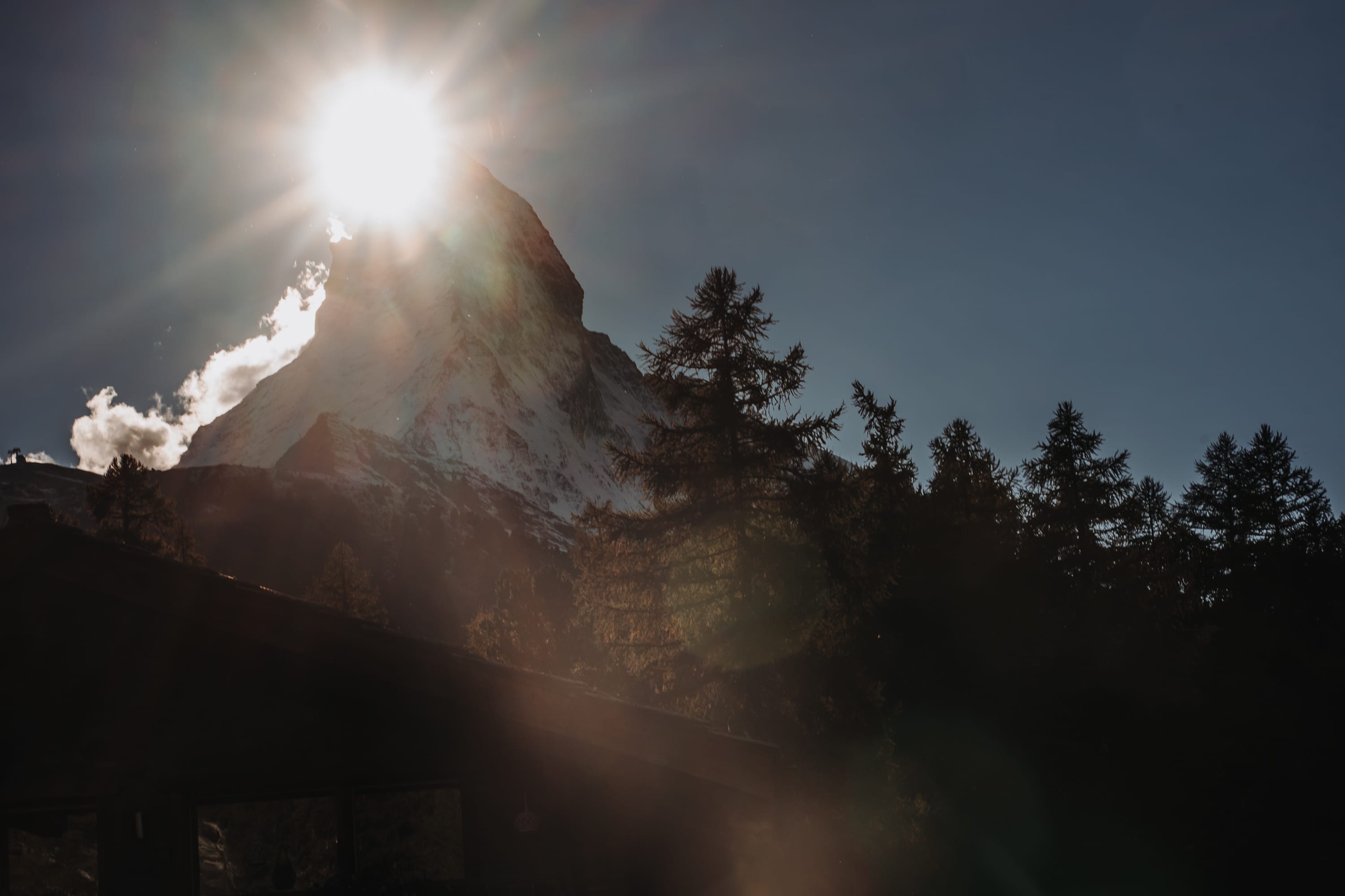 Die tiefe Sonne steht direkt neben dem Gipfel des Matterhorns