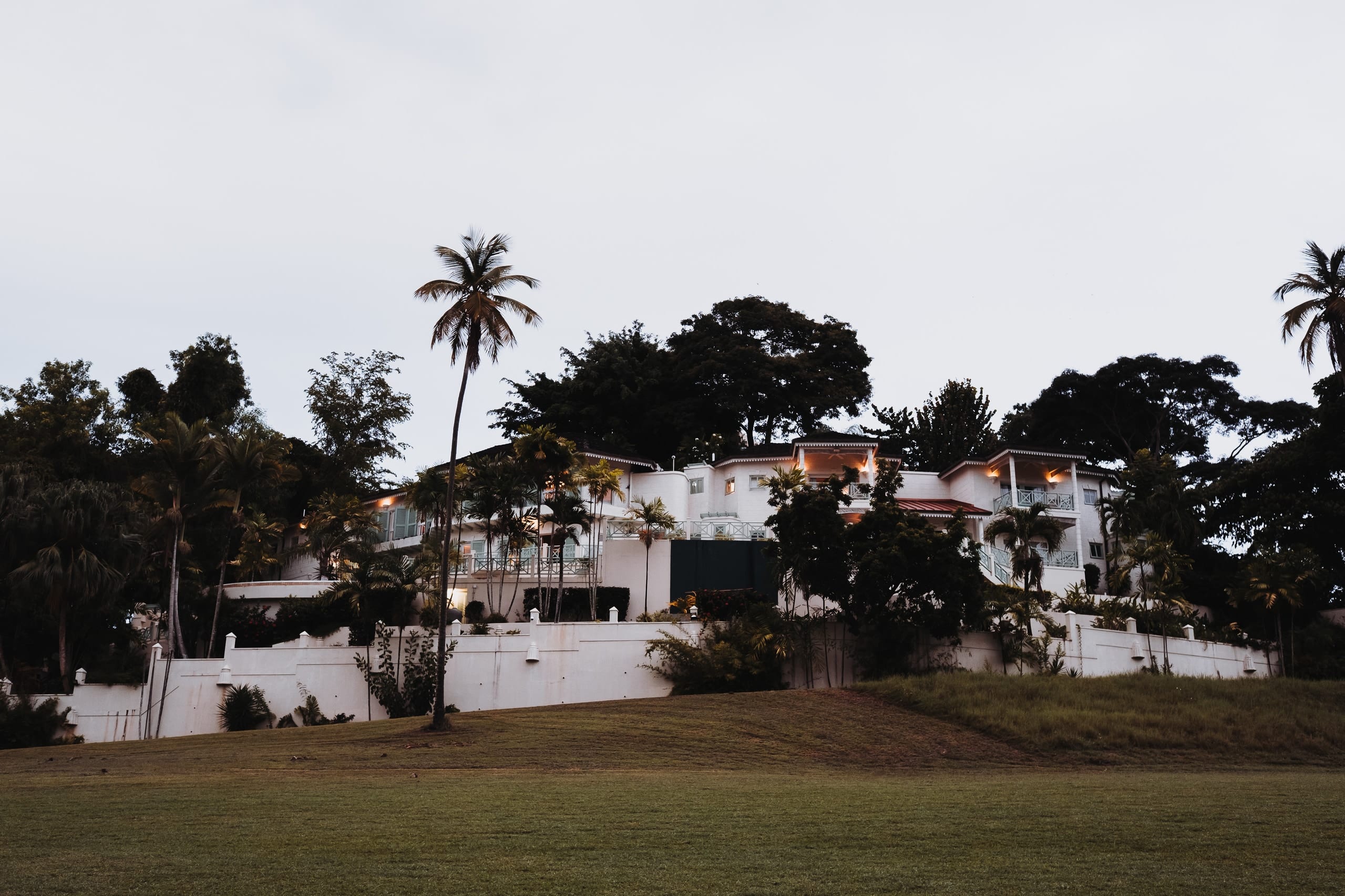 Die Villa Carpathia zwischen Palmen auf einem Hügel, in einigen Fenstern brennt Licht