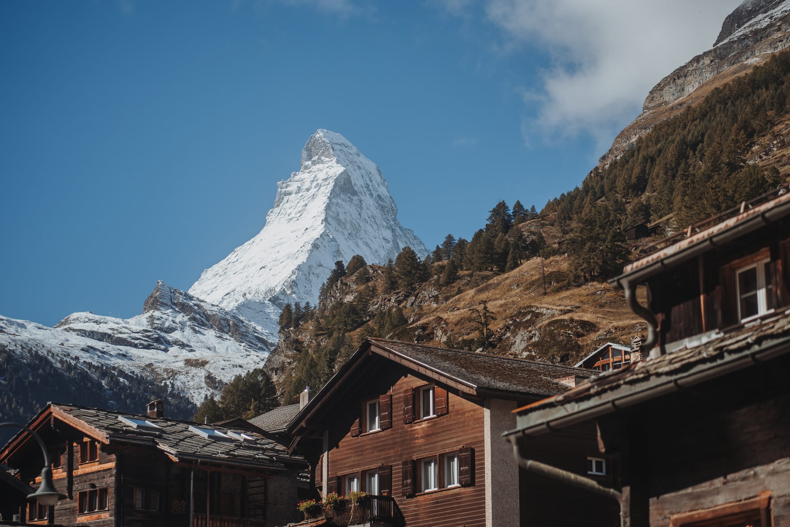 Holzchalets im Dorf Zermatt, dahinter das Matterhorn im Morgenlicht