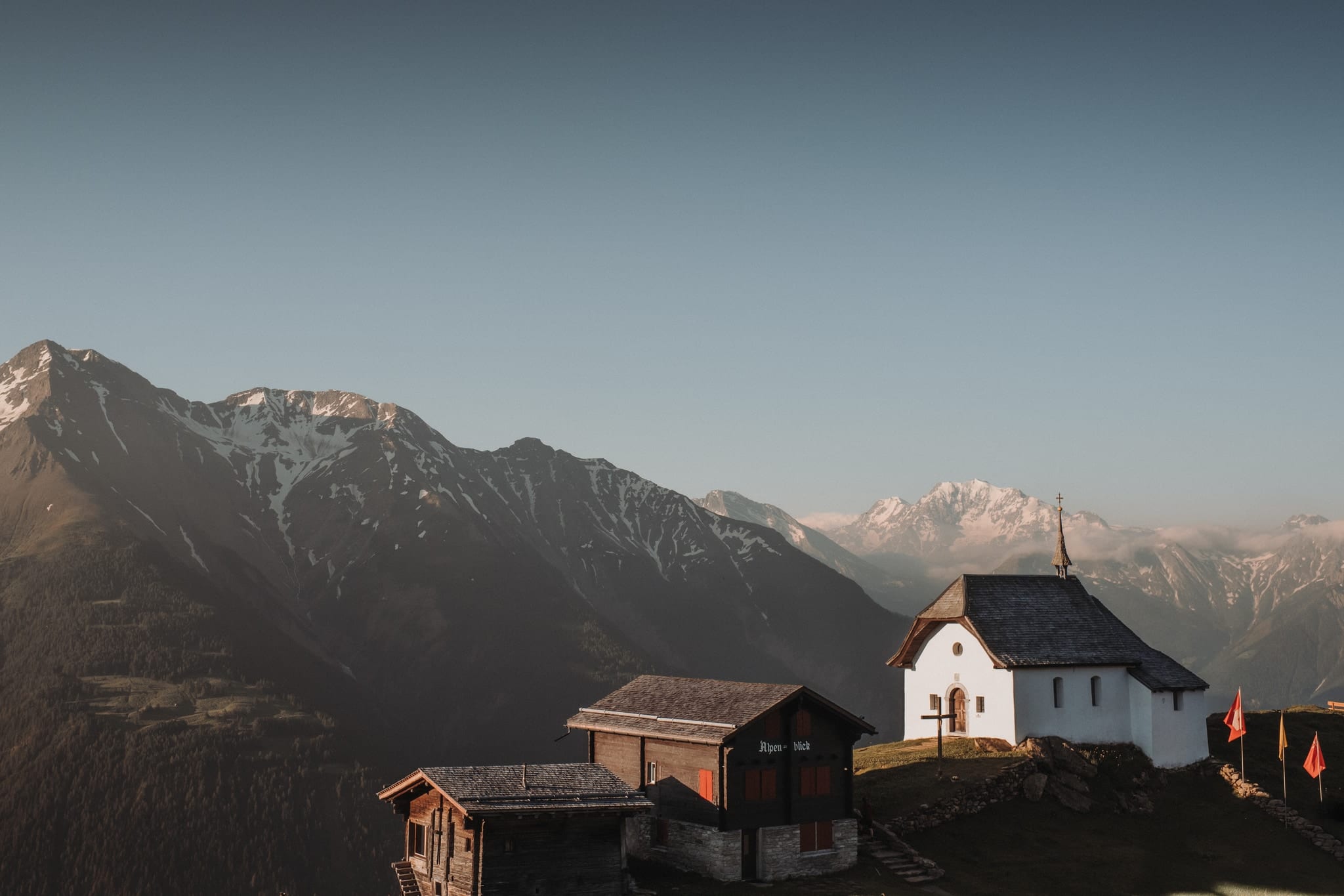 Die weisse Kapelle der Bettmeralp im Abendlicht, dahinter die Walliser Alpen