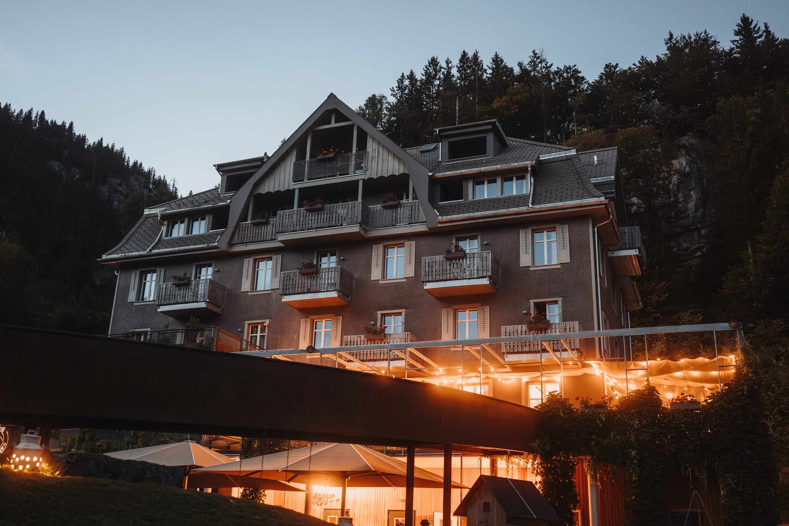 Das Hotel am Hasliberg in der Dämmerung, unter dem Vordach leuchten Lichterketten