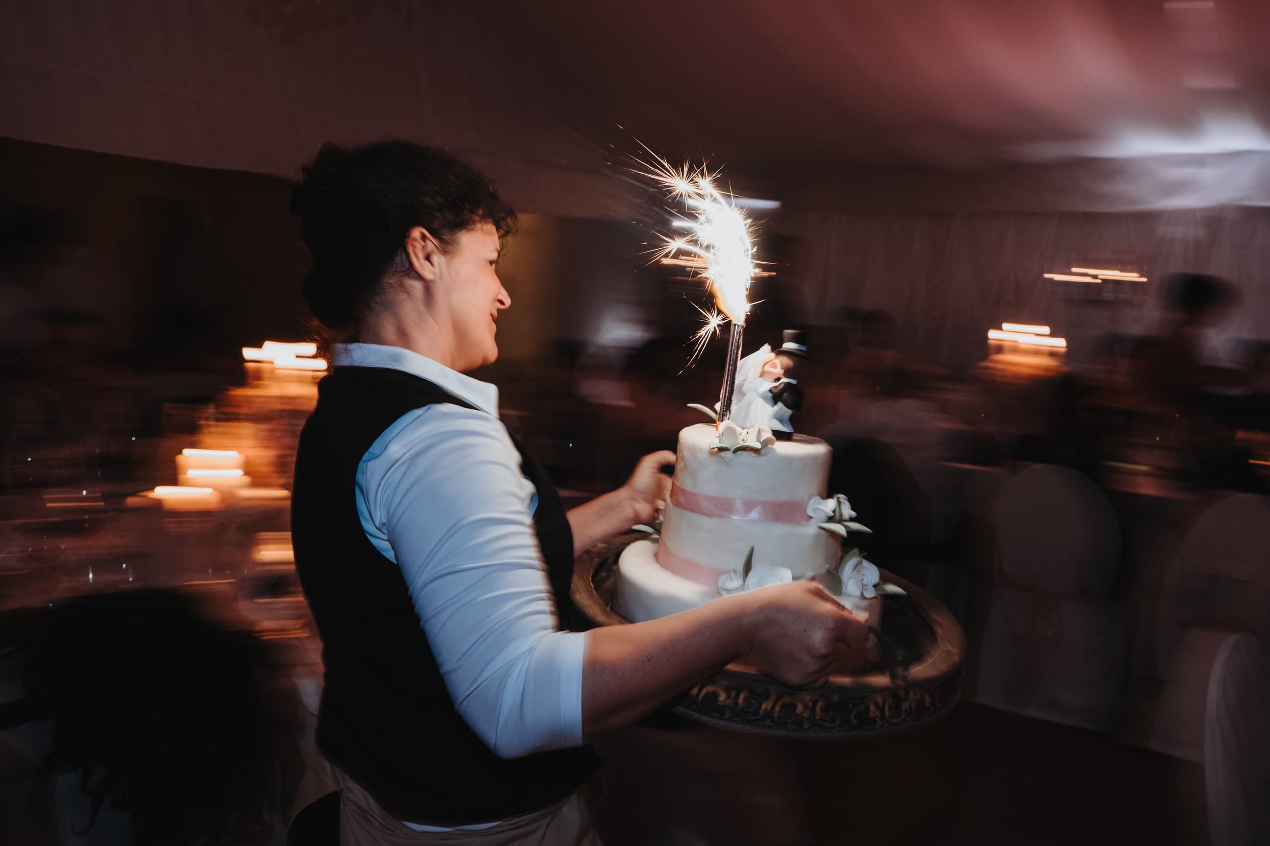 Die Hochzeitstorte wird mit einer Wunderkerze hereingetragen