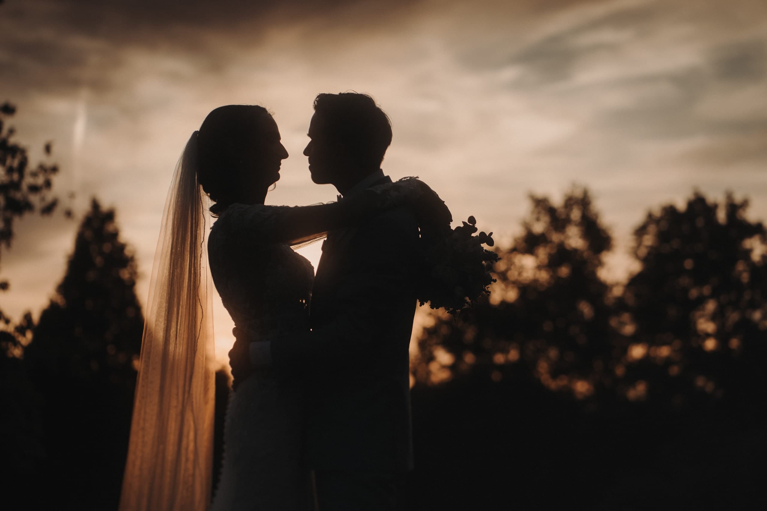 Das Brautpaar als Silhouette vor dem Abendhimmel beim Schlössli Utenberg