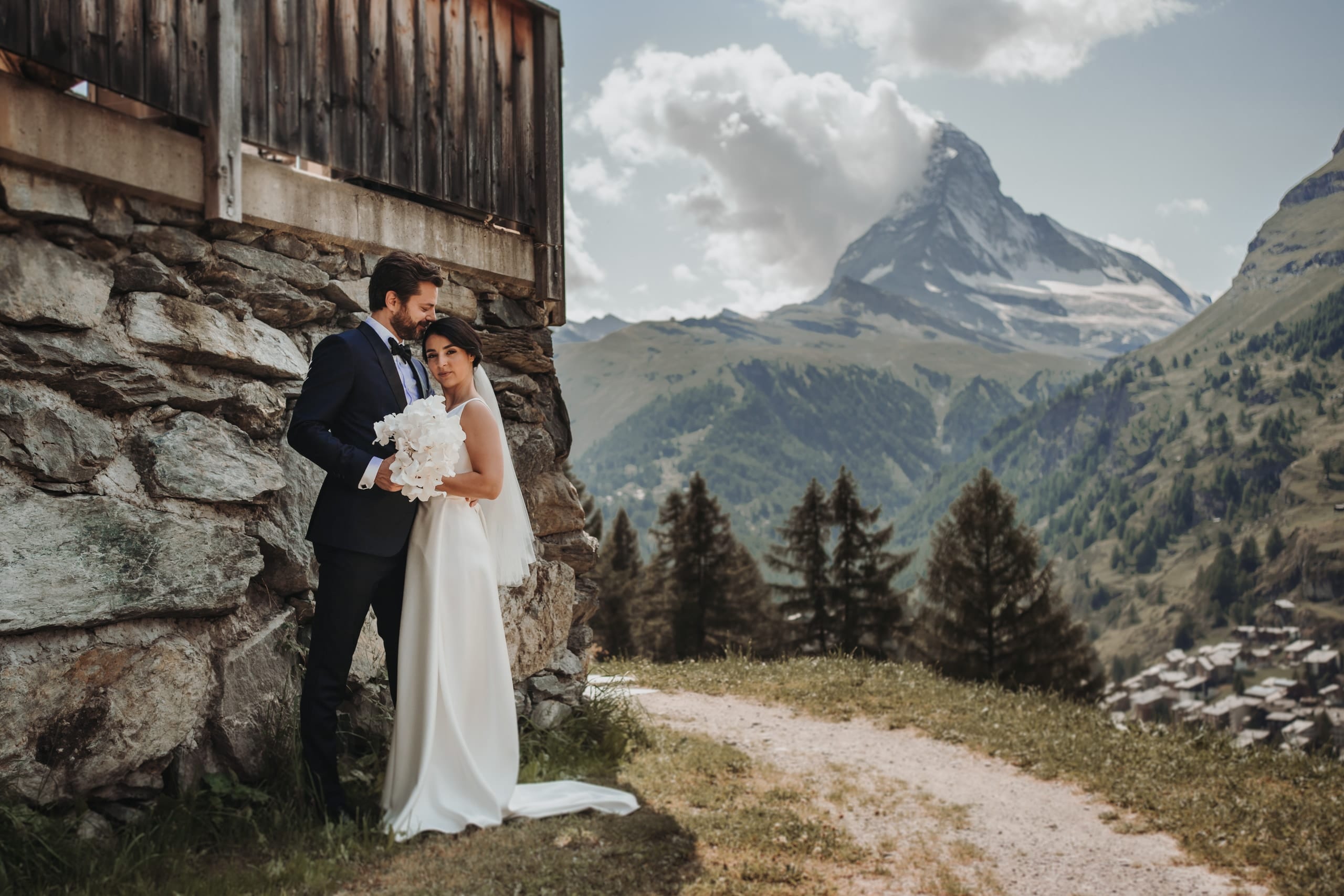 Braut und Bräutigam an einer alten Steinhütte bei Zermatt, im Hintergrund das Matterhorn