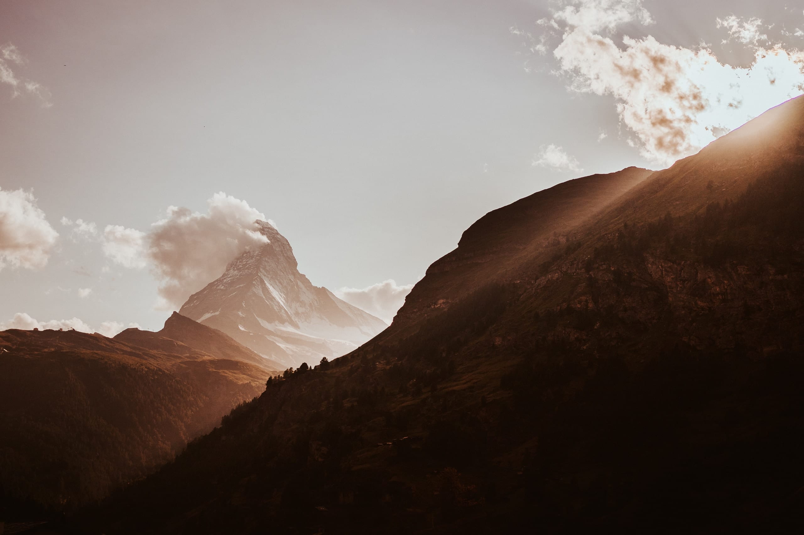 Das Matterhorn im Gegenlicht, davor ein dunkler Berghang